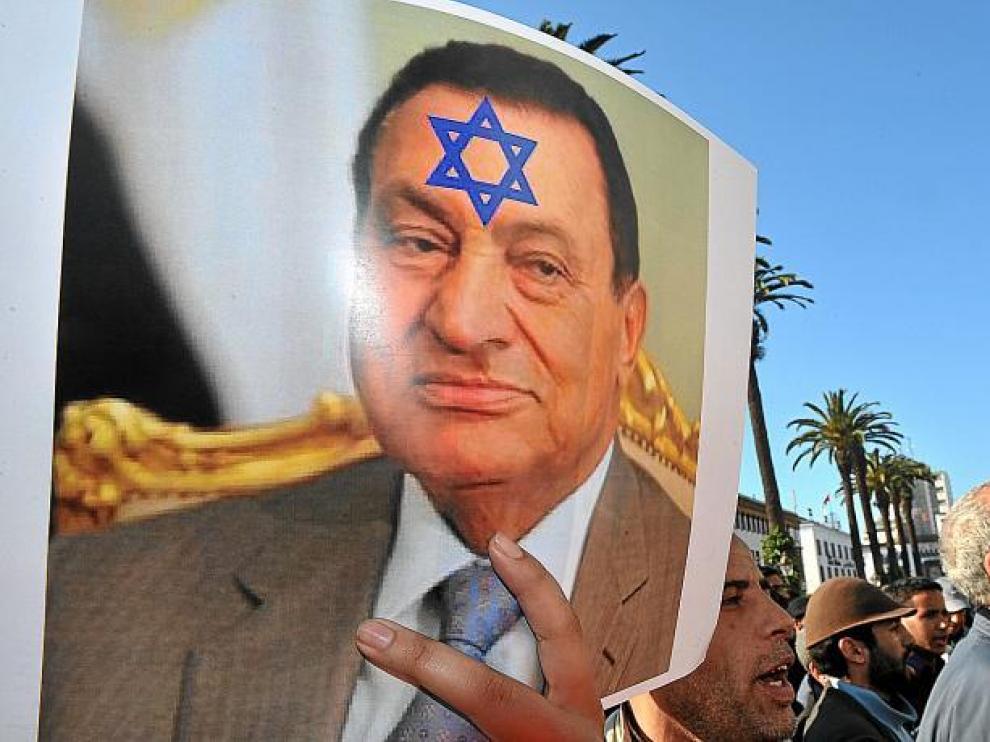 Una mujer muestra un póster con la imagen del ex presidente Mubarak con la estrella de David en su frente.