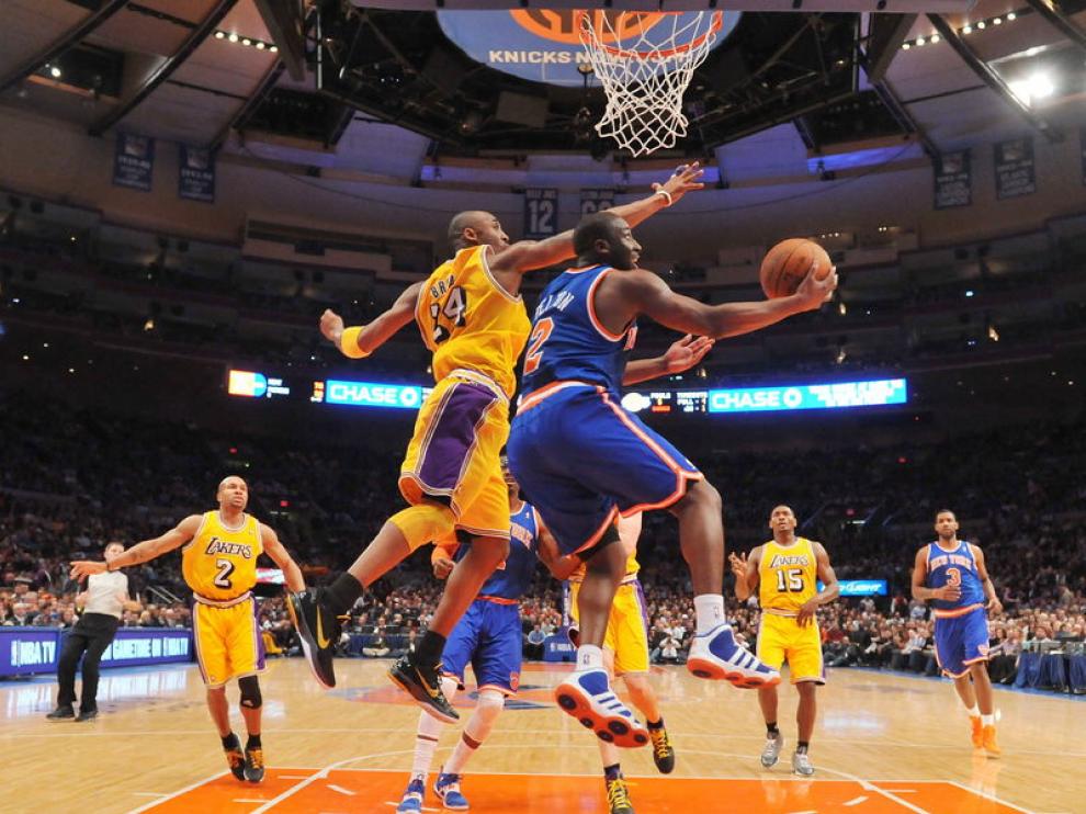 El jugador Kobe Bryant trata de evitar la anotación de Raymond Felton