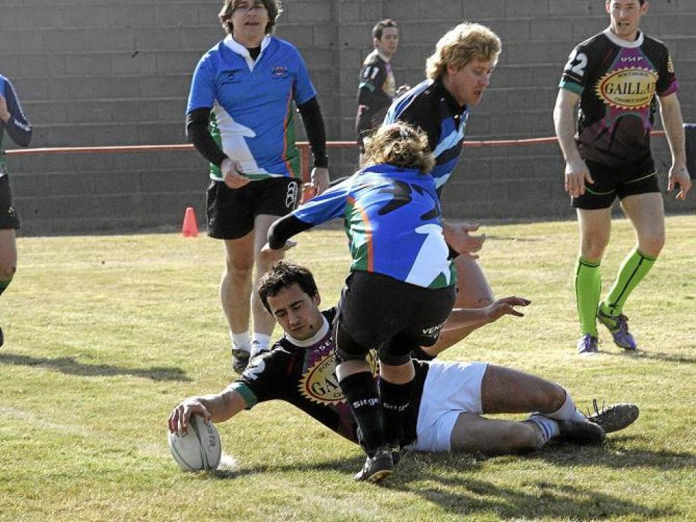 El equipo Touch Pyrénéés Rugby de Tarbes, Francia, consigue anotar un ensayo pese a la oposición de una jugadora rival.