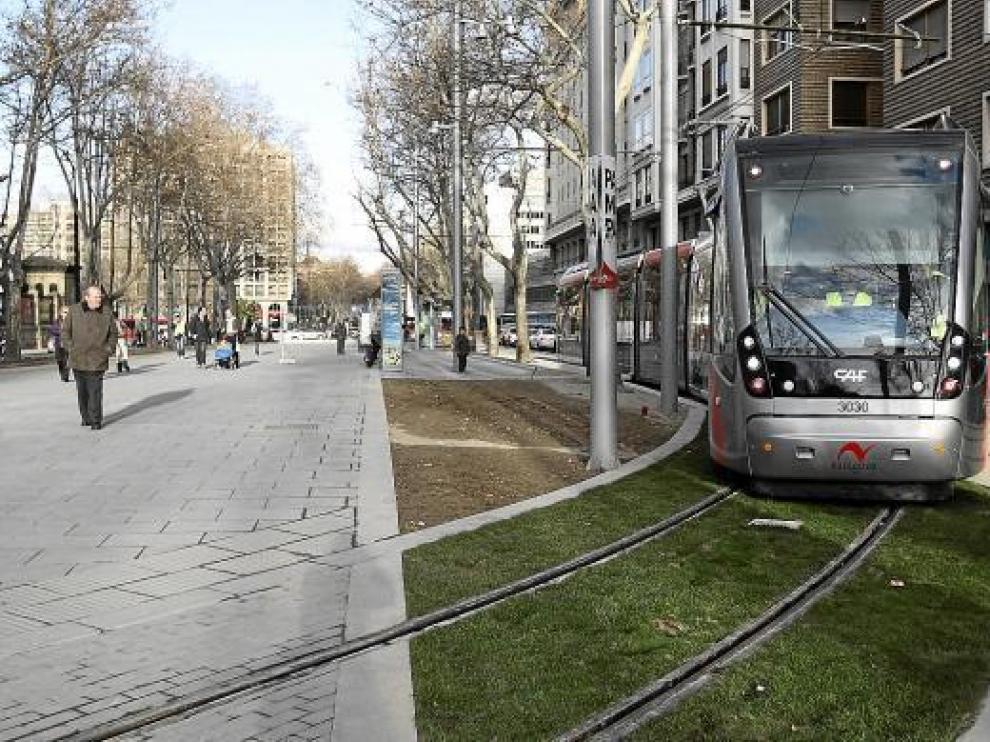 El tranvía enfila la vía de escape por el bulevar de Gran Vía ante la mirada de los viandantes.