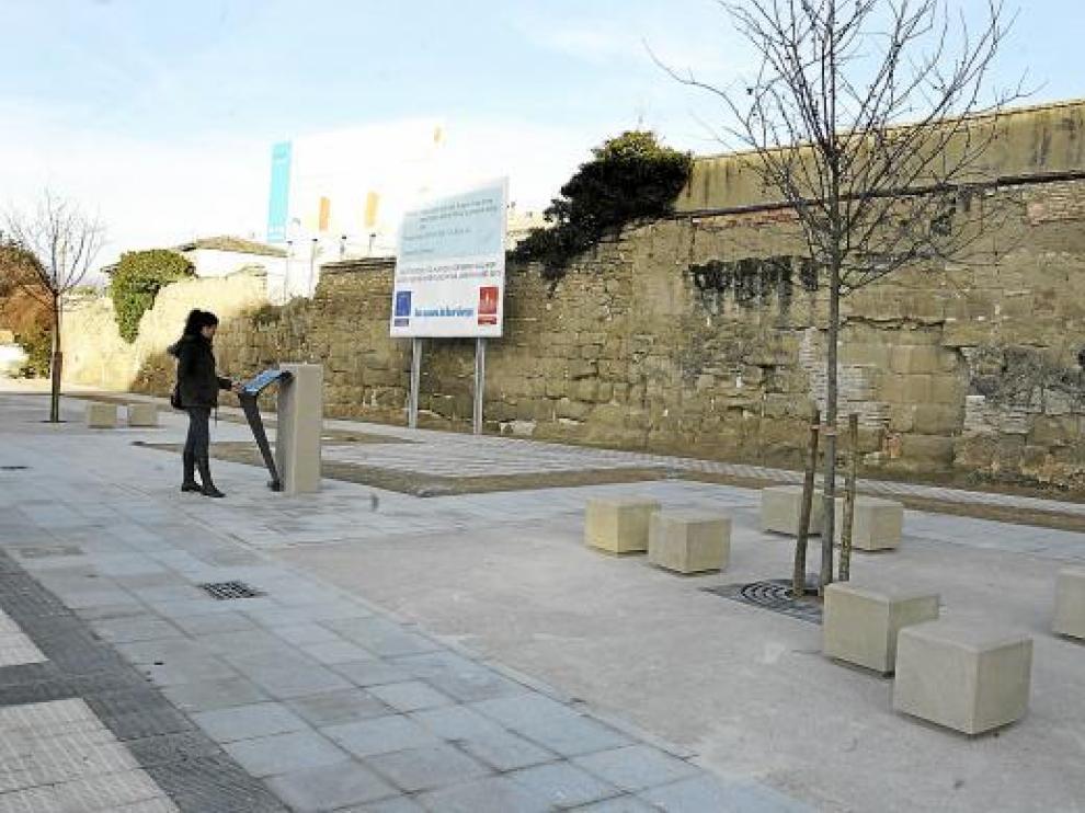 Una joven lee la placa explicativa colocada en el nuevo paseo de la calle de Joaquín Costa.