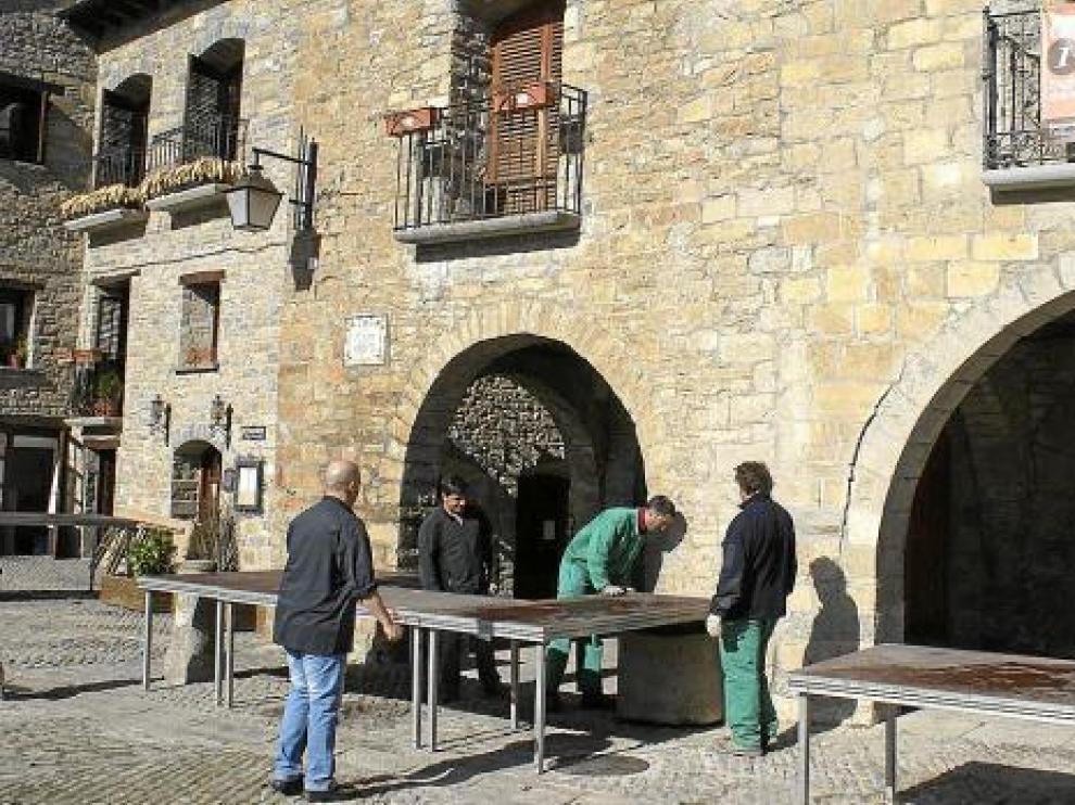 Los operarios preparaban ayer las mesas en la plaza y cocinas improvisadas bajo los porches.