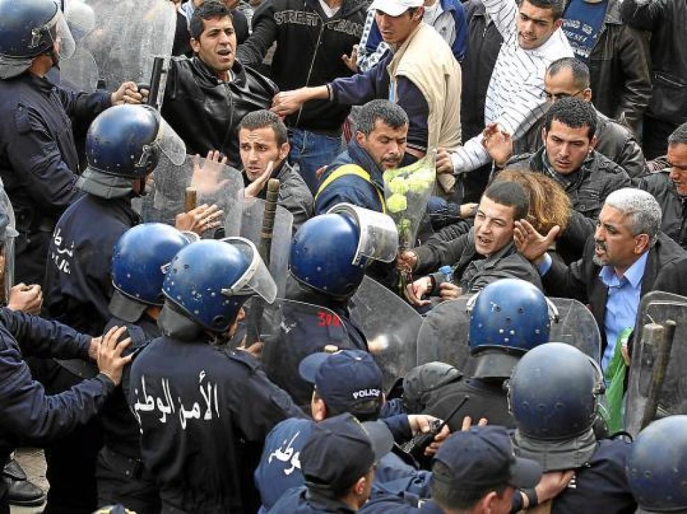 Varios policías antidisturbios tratan de contener a los manifestantes, ayer en Argel.