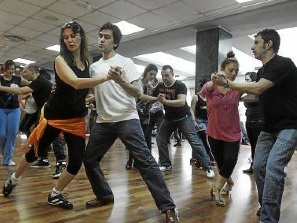 Varios participantes bailan salsa en uno de los talleres.