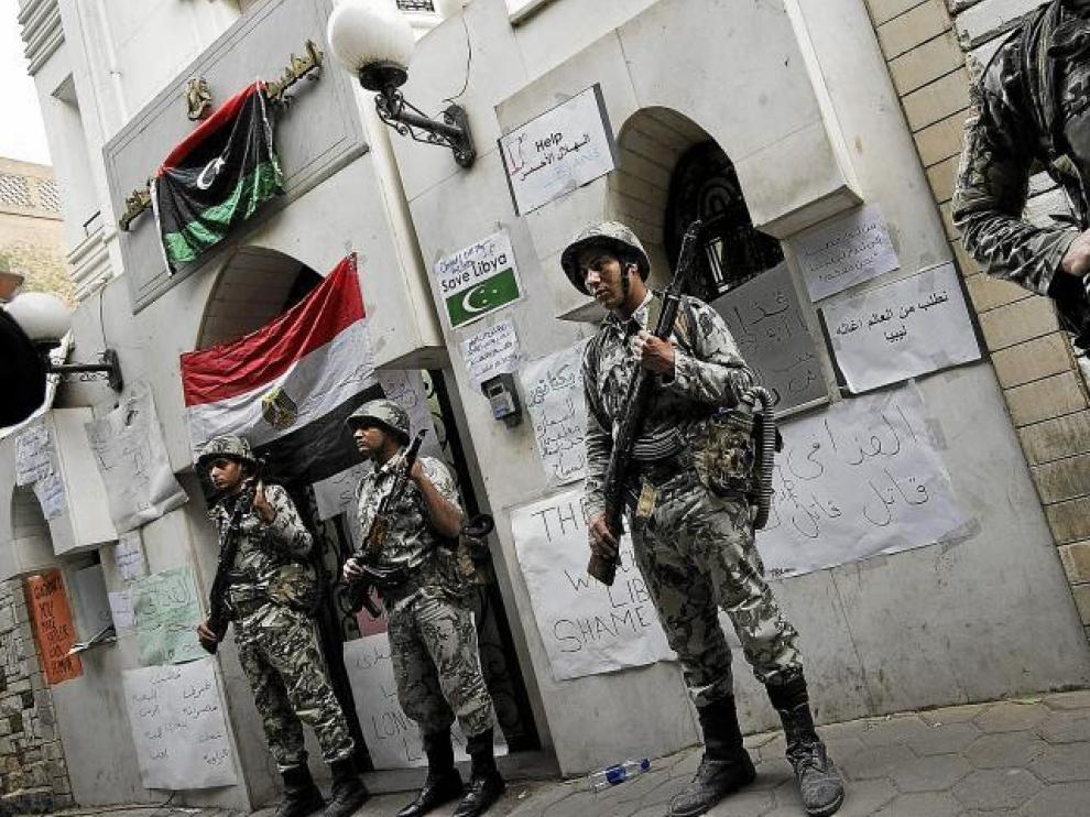 Soldados egipcios custodian la embajada de Libia en El Cairo, repleta de carteles contra el régimen.