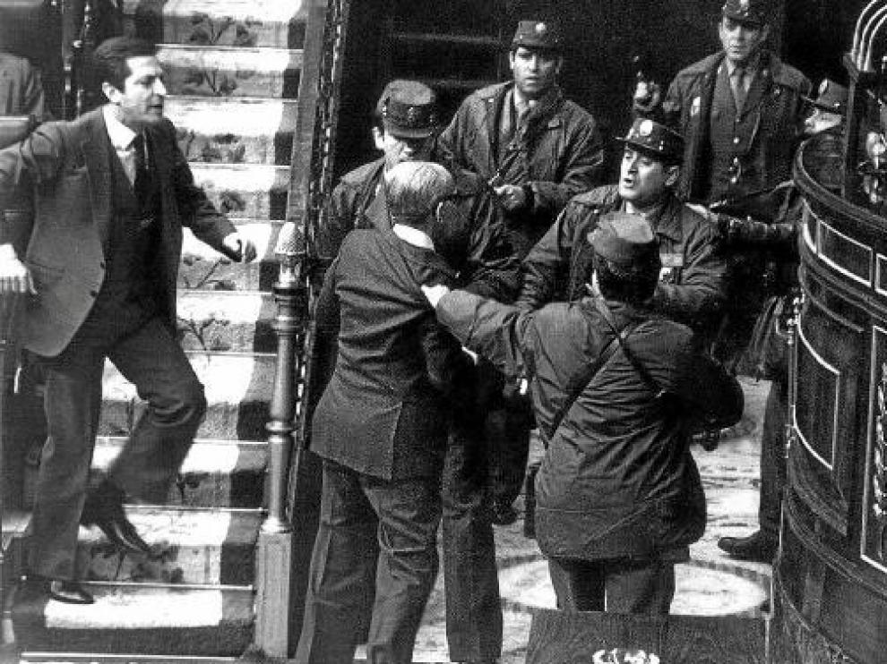 Gutiérrez Mellado, zarandeado por agentes ante Tejero (d) mientras Suárez (i) intenta socorrerle.