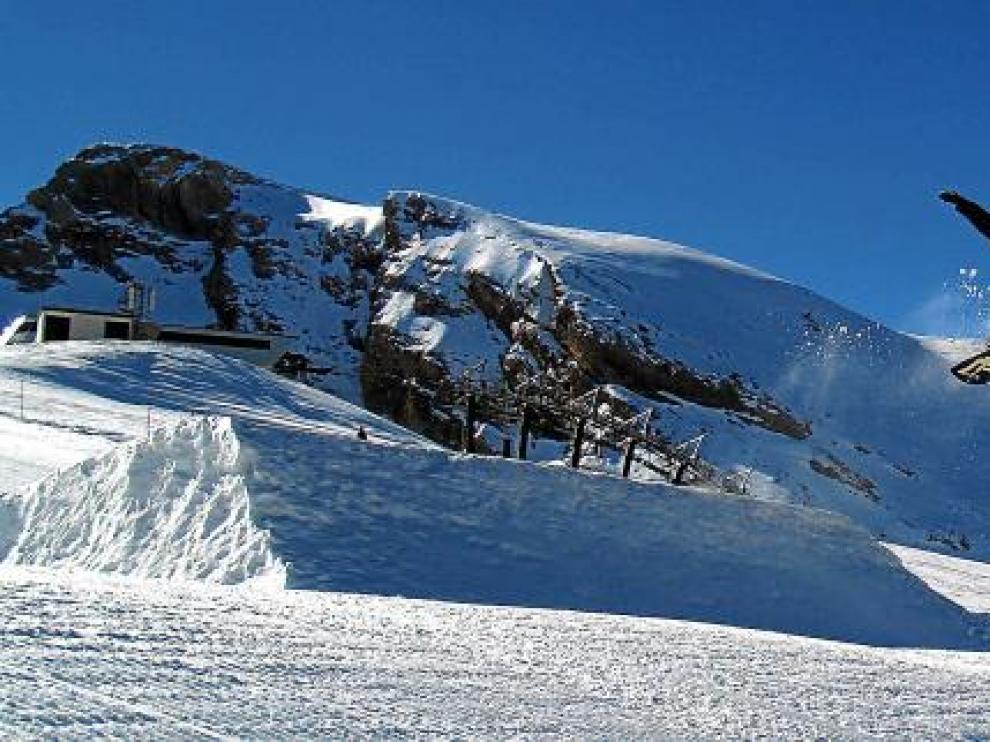 Un snowboard 'vuela', tras saltar uno de los módulos diseñados en el snowpark, en la pista de Basibé de la estación de esquí de Cerler.