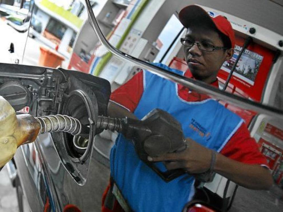 Un empleado de una gasolinera llena el depósito de un coche, ayer en Indonesia.
