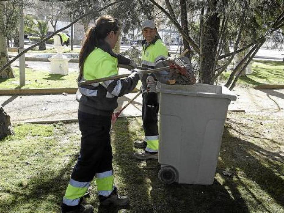 Dos empleados de la brigada limpian una de las decenas de zonas verdes que hay en la ciudad.