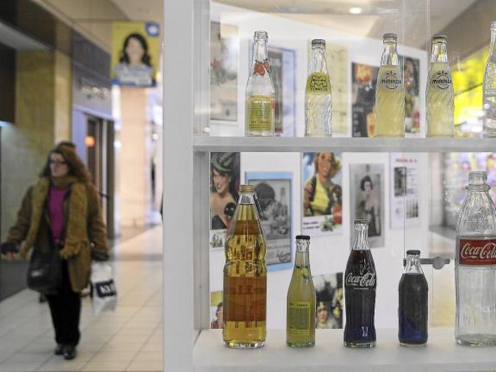 Imagen de una de las vitrinas colocadas en el Centro Comercial Augusta de Zaragoza, con envases de bebidas de distintas décadas.