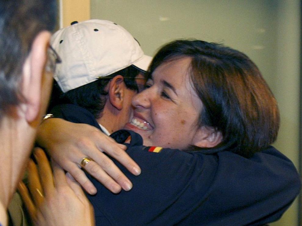 Una mujer abraza hoy en Barajas a un empleado de Repsol, recién llegado de Libia