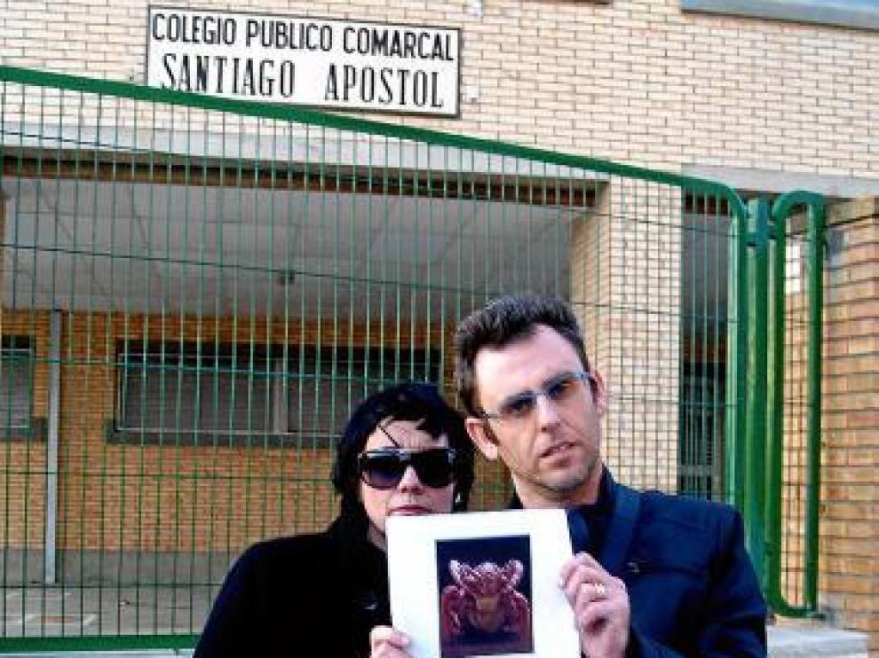Mancilla y Rivarés, ante el centro con el cartel que han elaborado.