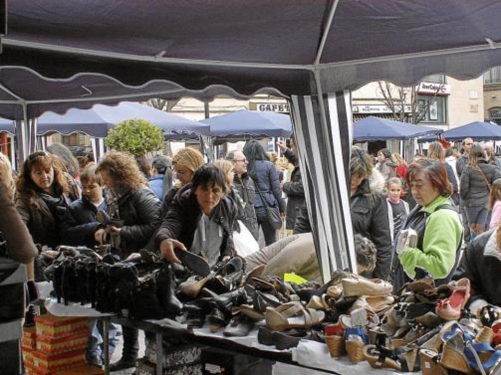 Un grupo de mujeres mira las ofertas de un puesto de zapatos, ayer en Caspe.