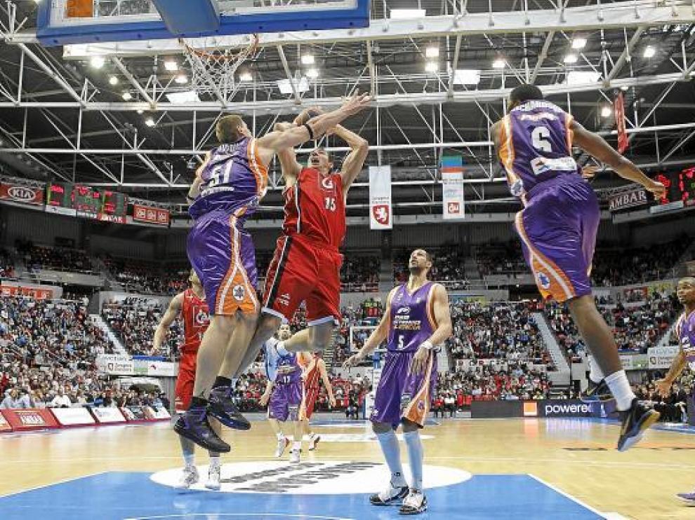 Adam Chubb intenta un lanzamiento mientras Javtokas y Richardson se elevan para evitarlo.