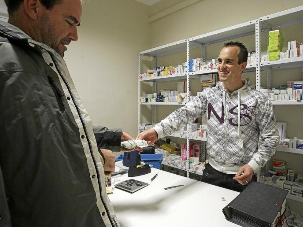 El farmacéutico de Loporzano atiende a un cliente en el dispensario de Tierz.