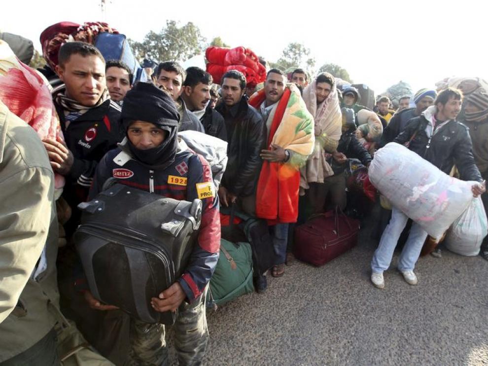 Ciudadanos egipcios residentes en Libia esperan junto a sus pertenencias en el paso tunecino de Ras el Jedir