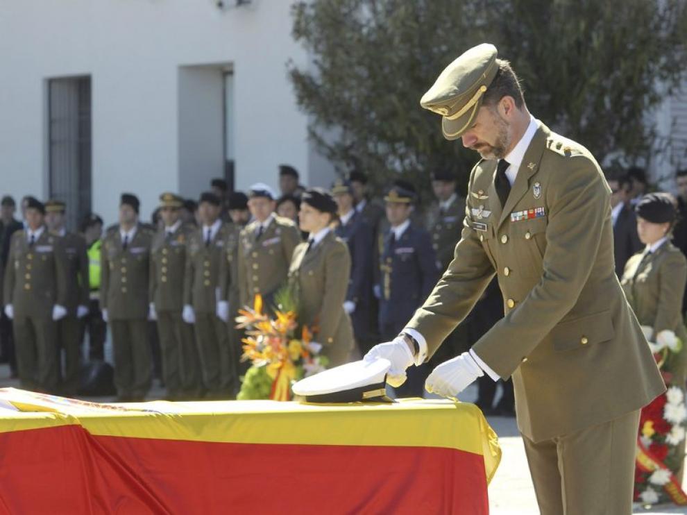 El príncipe de Asturias coloca la Cruz del Mérito Militar con distintivo amarillo en uno de los féretros de los cinco militares muertos el pasado jueves