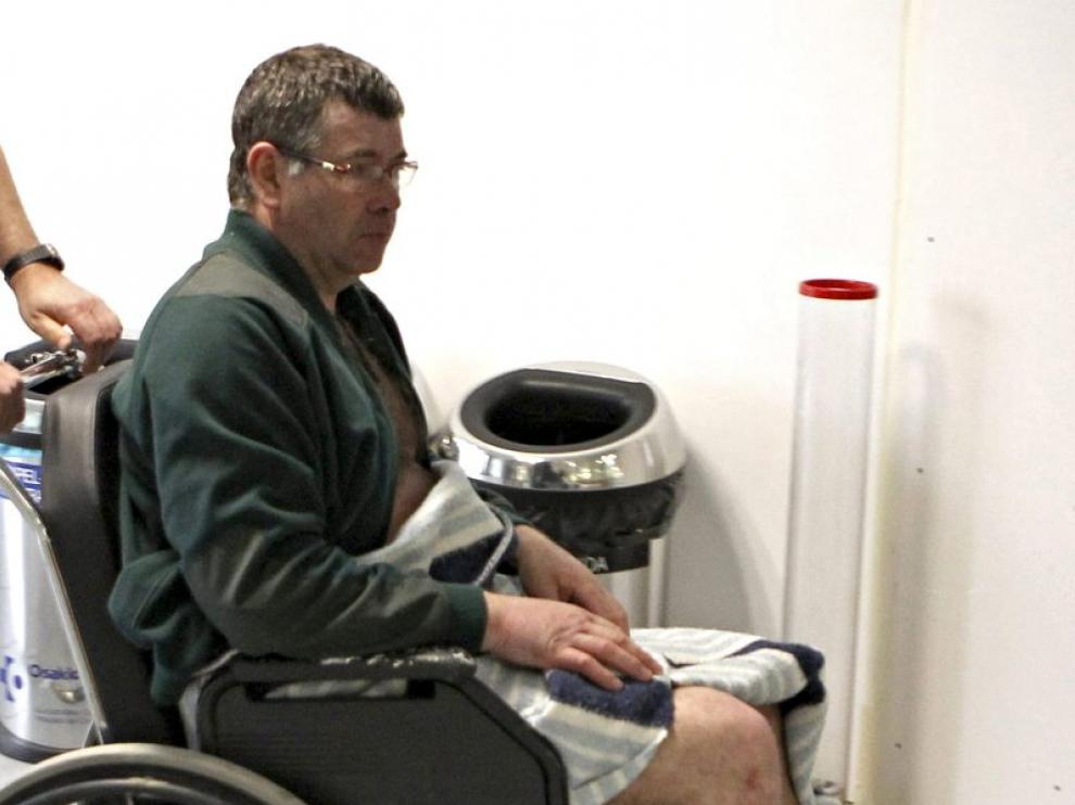 J.M.B. de 52 años, uno de los rescatados, es conducido en silla de ruedas en el hospital de Cruces