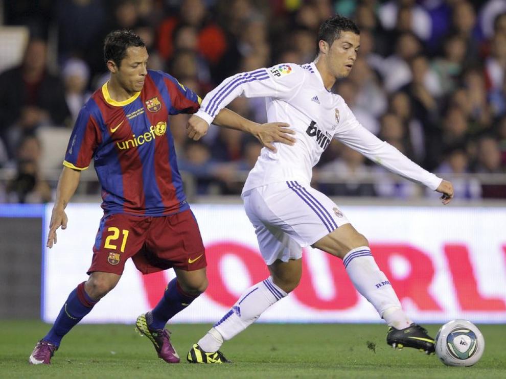 Cristiano Ronaldo controla un balón frente al defensa brasileño Adriano.