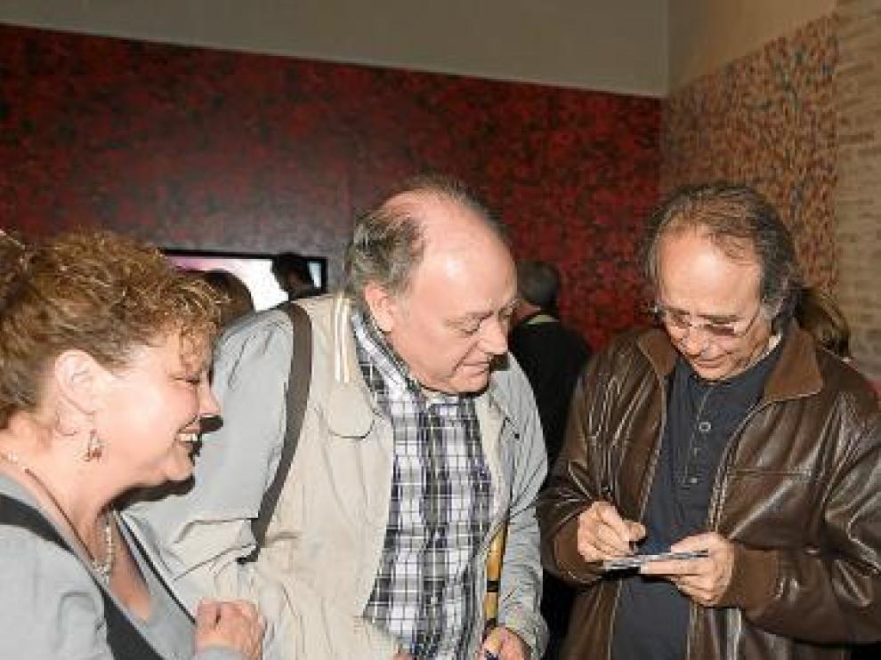 Serrat firma un disco para dos admiradores en La Almunia.