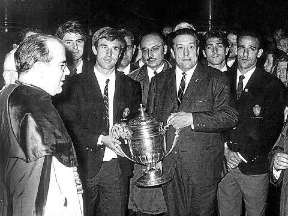 Lapetra sujeta el trofeo de Copa conseguido por el Real Zaragoza en 1966. Lo hace a la vez con Waldo Marco, presidente en aquella época. A la derecha figura el brasileño Canario.
