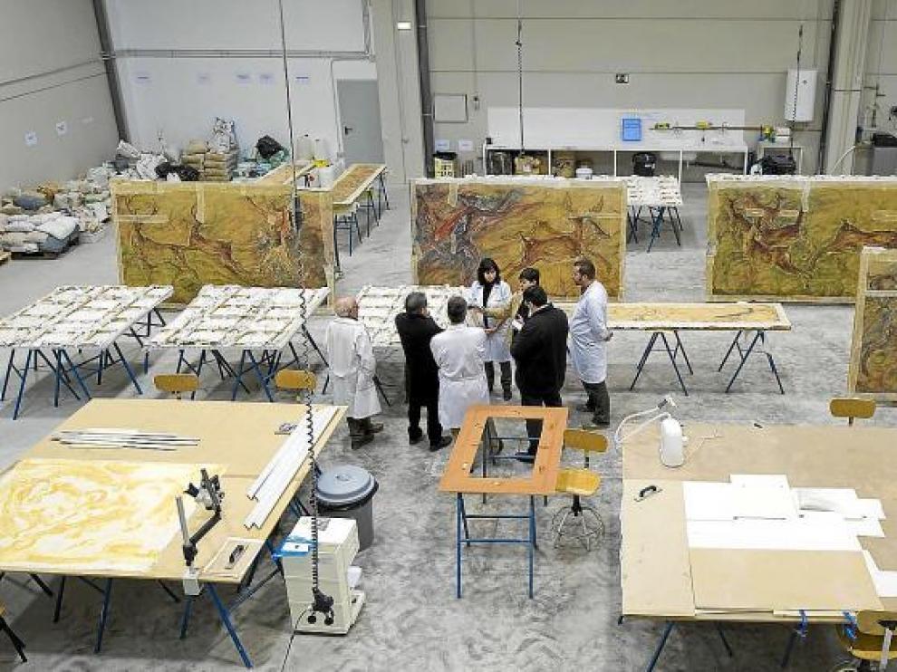 Vista parcial de la nave donde trabaja la Escuela Taller, con el mural de Ciria para el Teatro Fleta en proceso de restauración .