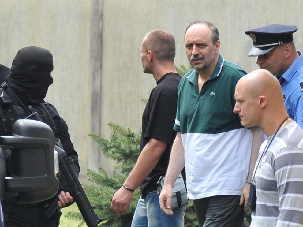 El ex militar serbio Goran Hadzic es escoltado por la policía durante su traslado a La Haya.