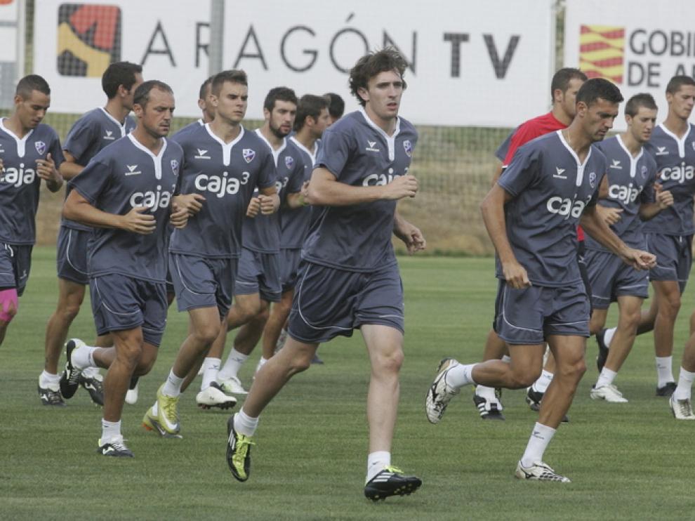 Los futbolistas del Huesca realizan carrera continua durante el entrenamiento de la tarde en el Instituto Montearagón.