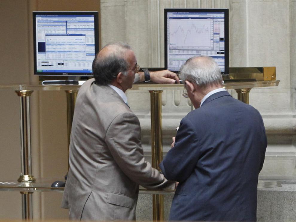 Dos inversores consultan los datos económicos en la Bolsa de Madrid