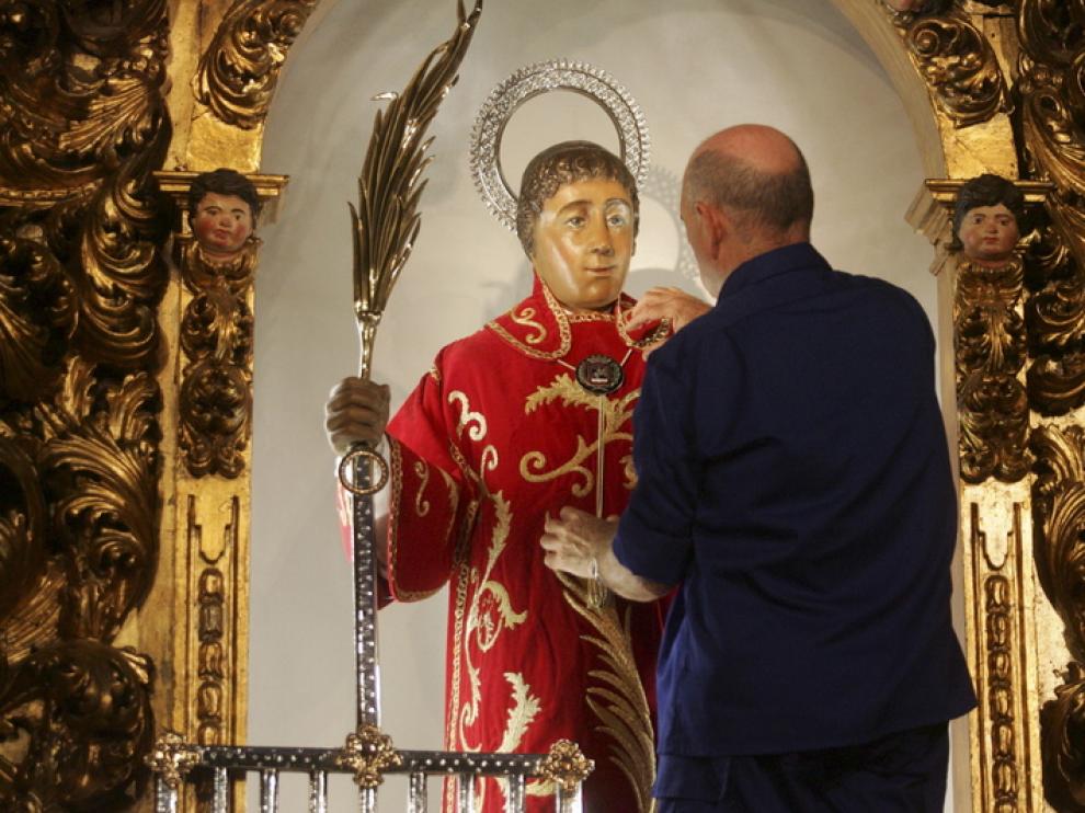Un voluntario ultima los detalles de la vestimenta que San Lorenzo lucirá la semana festiva.
