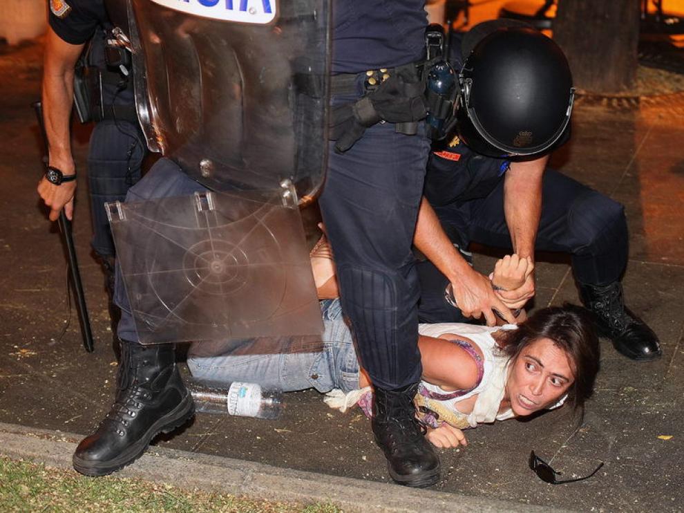 Un policía reduce a una de los manifestantes en Madrid
