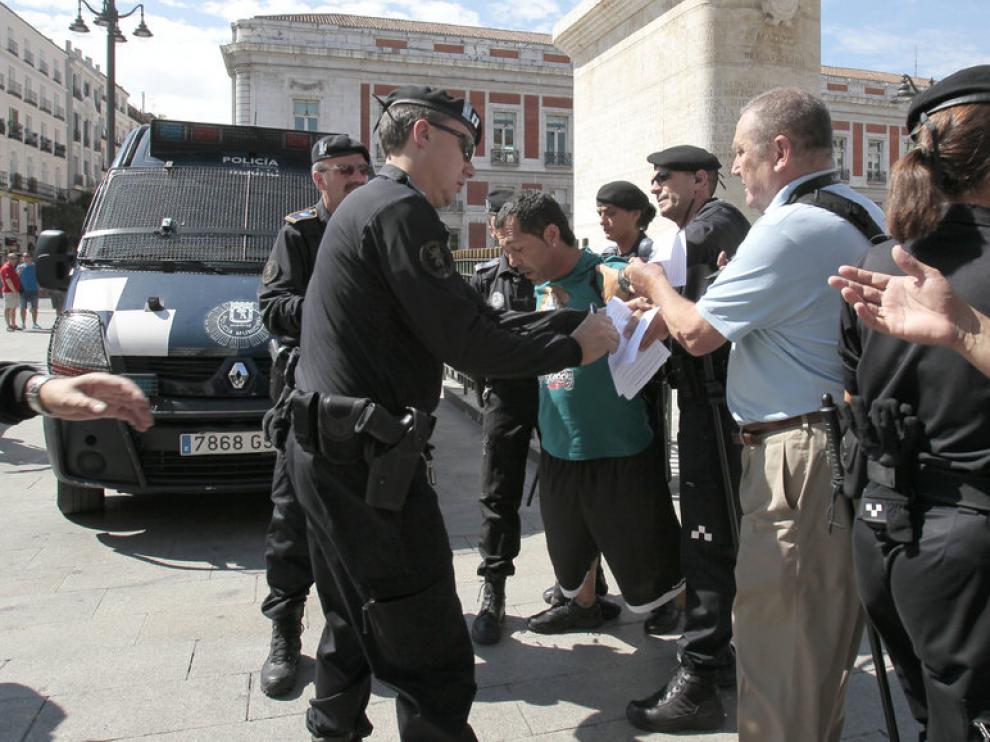 Agentes de la Policía Nacional piden la documentación a personas que se acercan a Sol