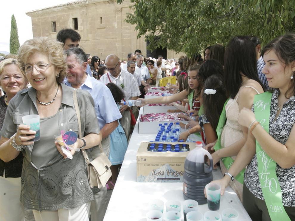 Los representantes de la peña Os Casaus hacen su ofrenda en Loreto.