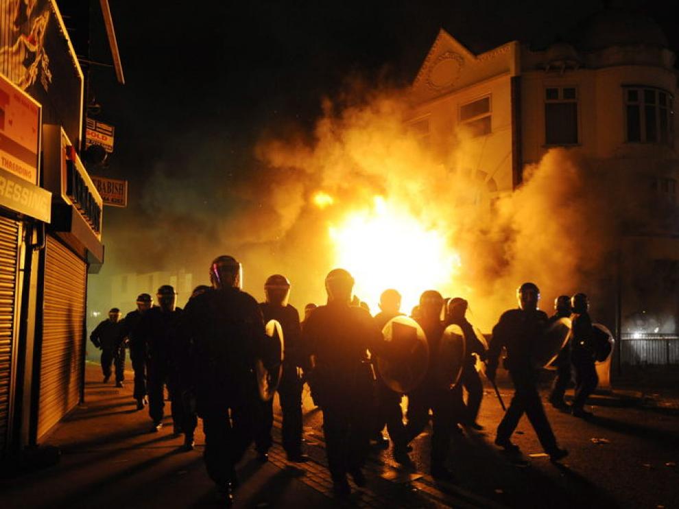 Policías antidisturbios han rodeado este martes un edificio incendiado en el barrio de Croydon