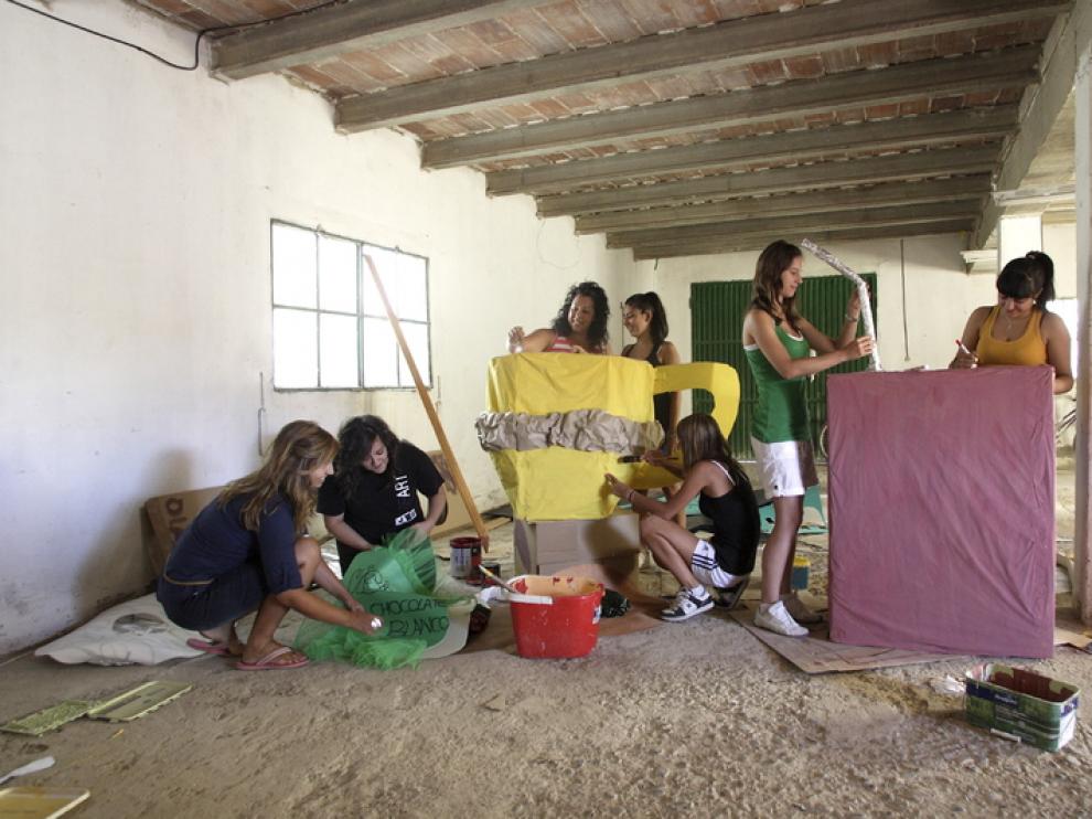 Las amigas de Ángela Marcén y Silvia Gascón han preparado unos disfraces y un remolque con el que sorprender a sus vecinos de San Mateo esta noche.