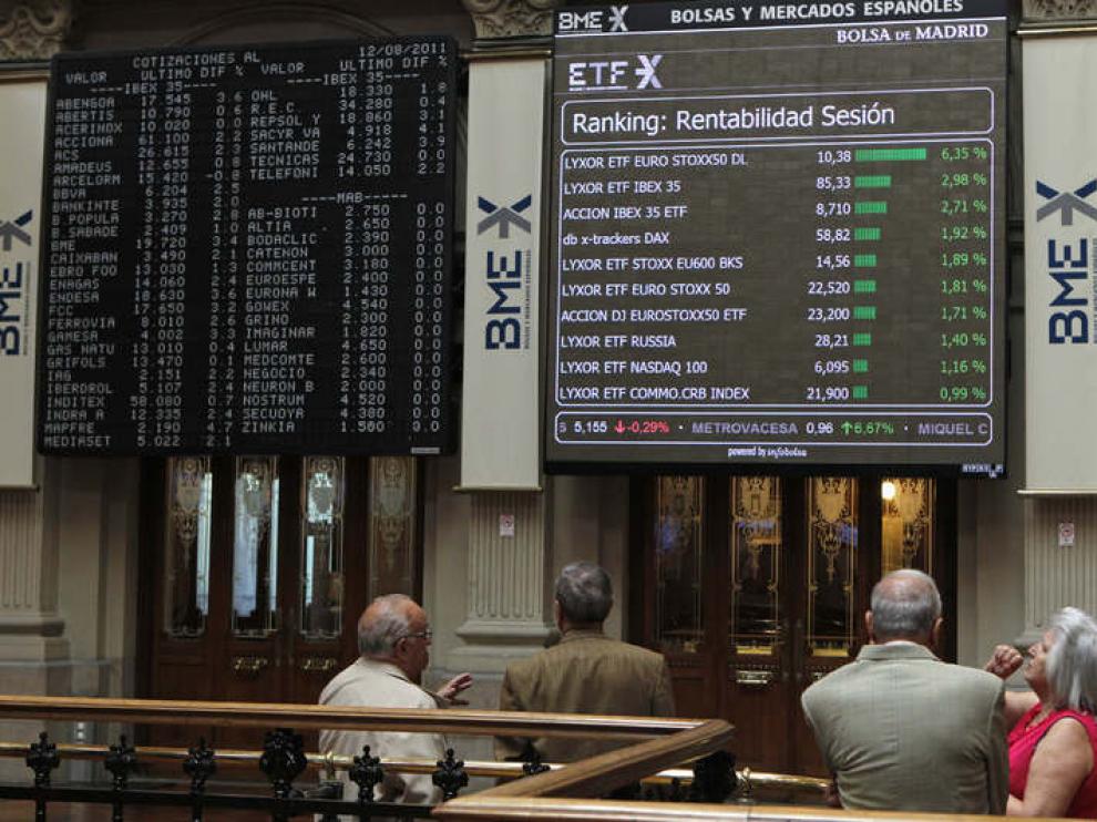 Varios operadores observan un panel en la Bolsa de Madrid
