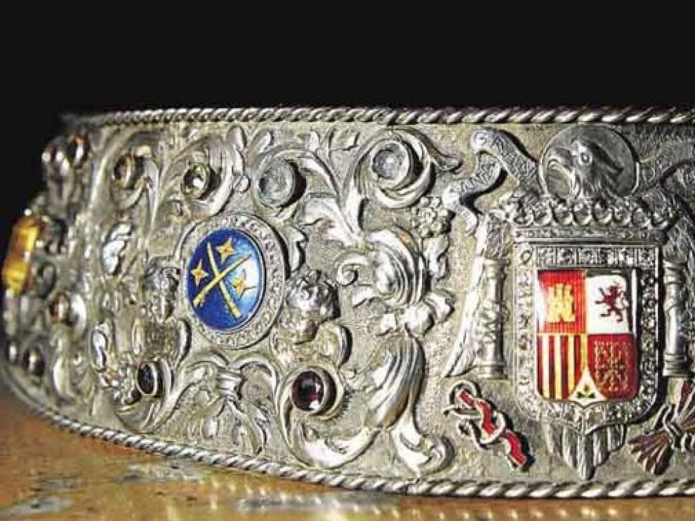 Broche que sujeta habitualmente el manto. Arriba, uno de sus esmaltes, con el escudo del Cabildo