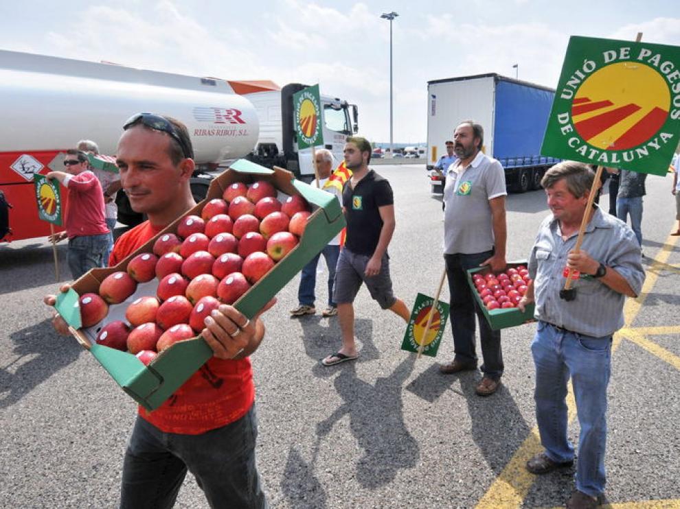 Un grupo de agricultores repartiendo fruta en la frontera de la Junquera