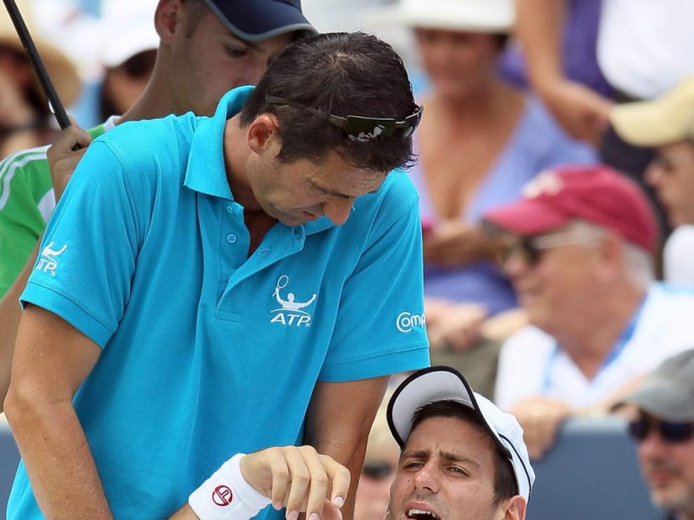 Novak Djokovic recibe las asistencias de su fisioterapeuta.