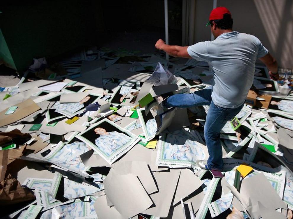 Un disidente destruye unos carteles del líder libio