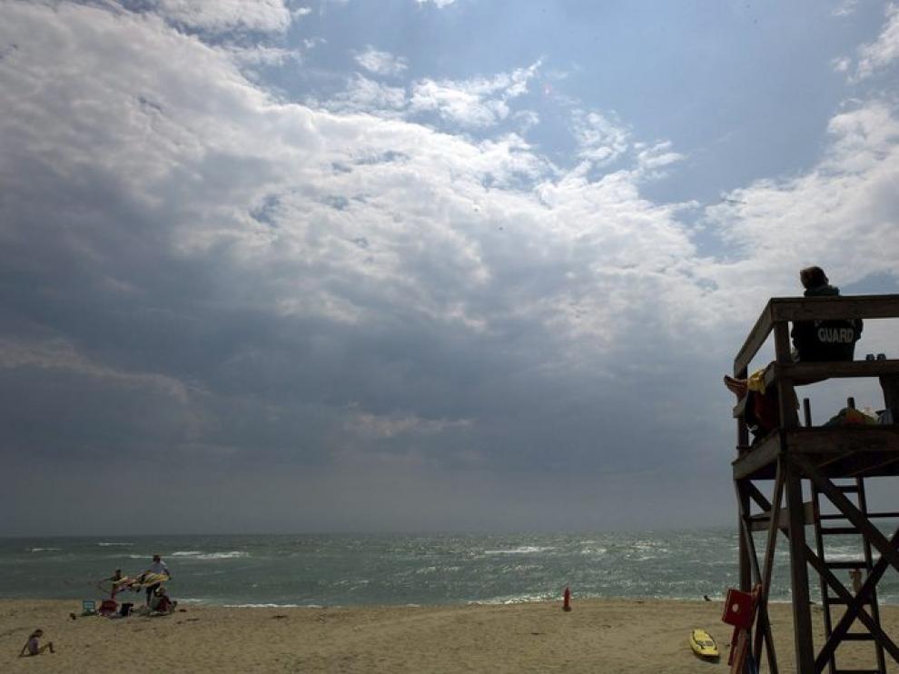 Un socorrista observa el cielo ante la llegada de Irene.