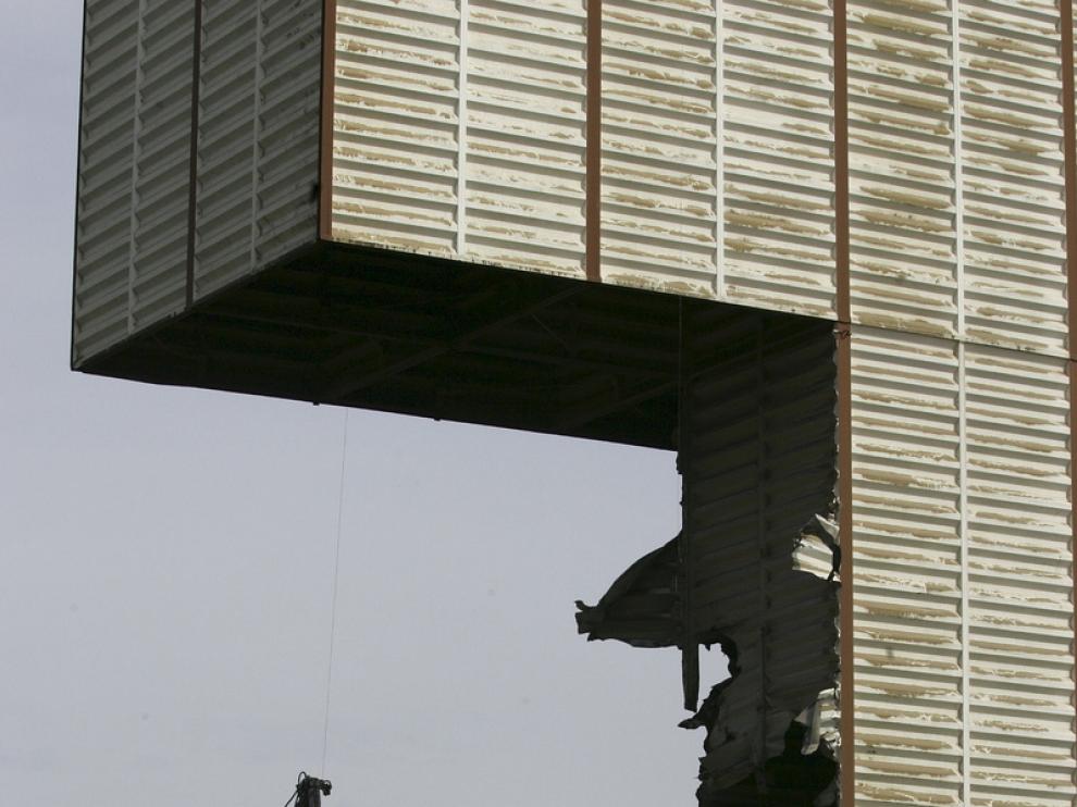 La máquina 'muerde' la chapa de uno de los silos de Villamayor, cuyo derribo está previsto que se complete mañana