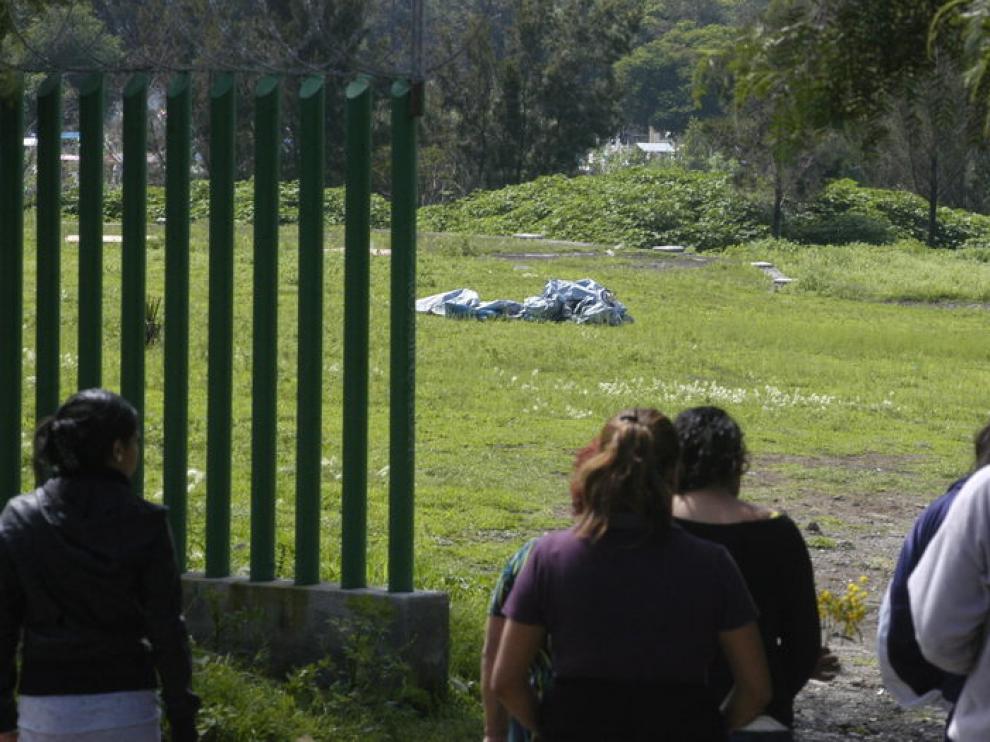 Varias personas observan la manta cubre los cuerpos de las periodistas mexicanas