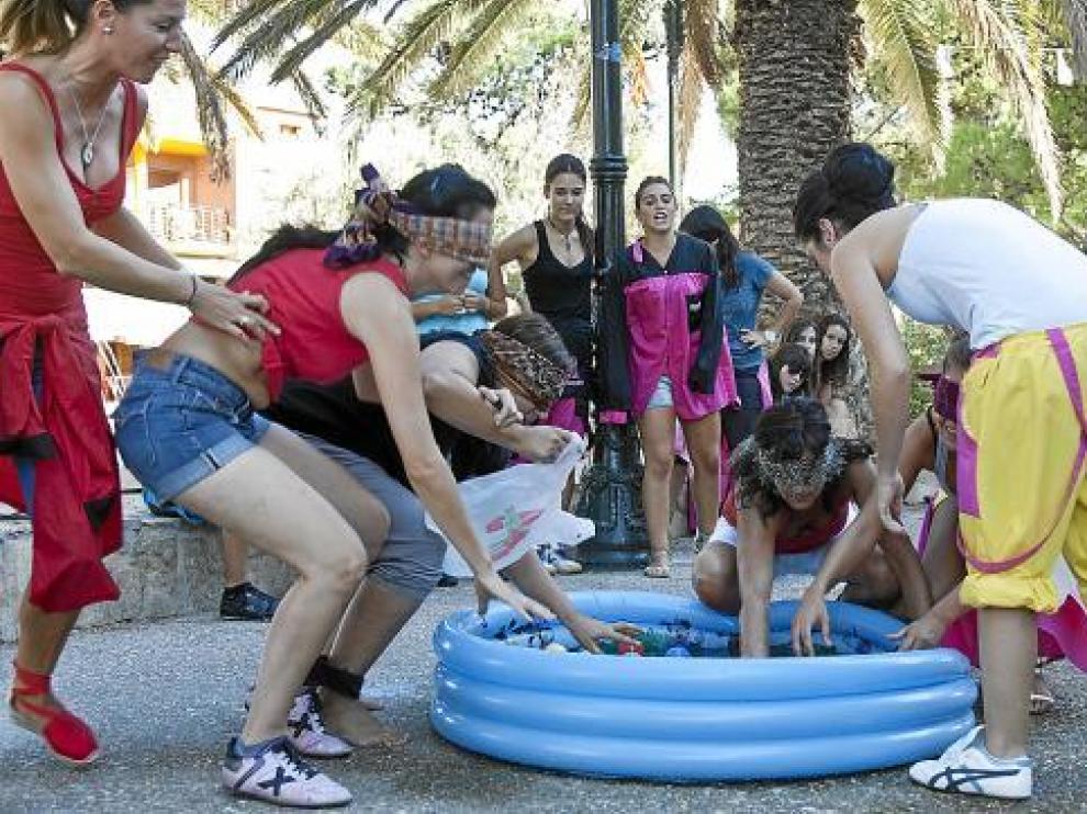 La peña Los Otros, de rojo, junto a las reinas de las fiestas, ayer en una de las pruebas.