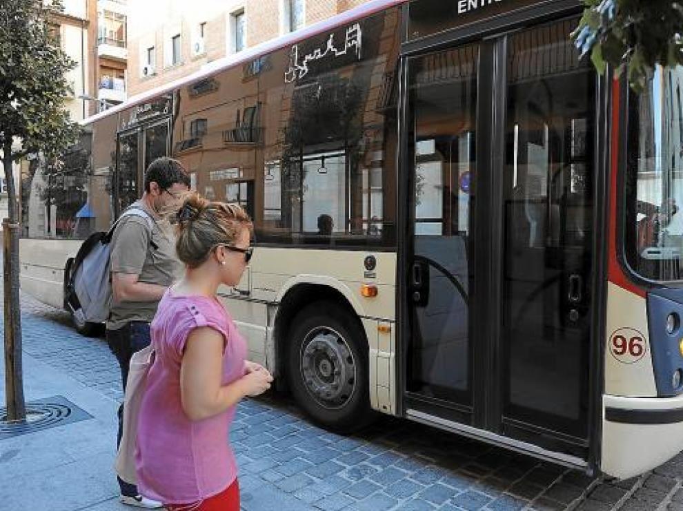 Dos usuarios toman el autobús en la calle Joaquín Arnau.
