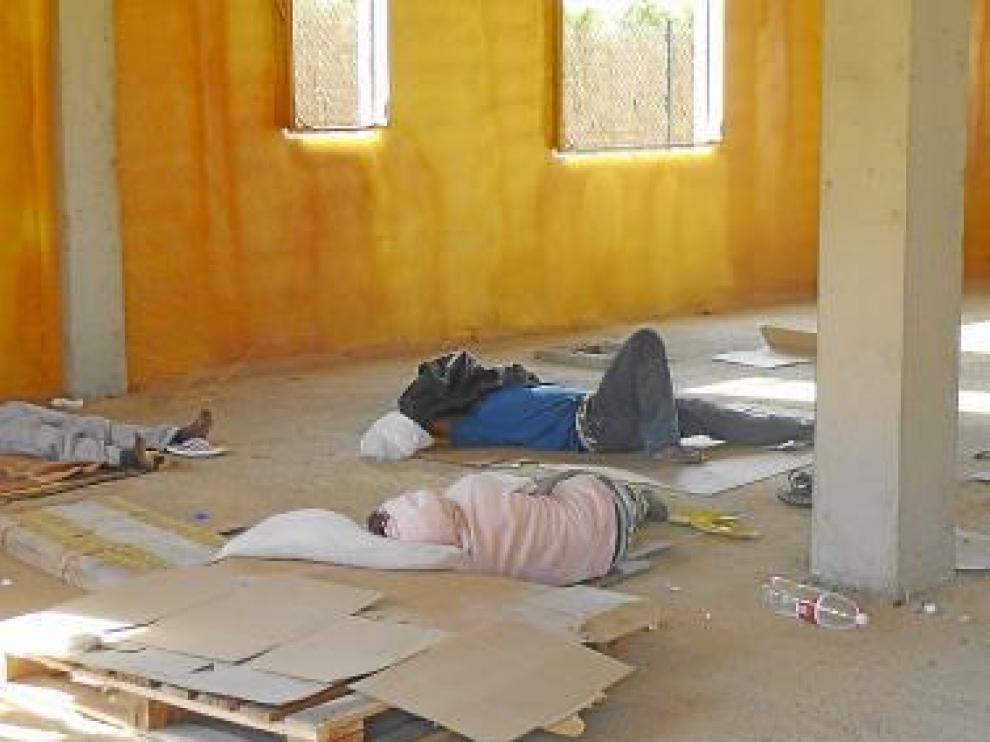Varios inmigrantes malviven en unas casas a medio hacer.