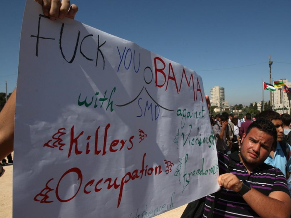 Ciudadanos palestinos portan pancartas contra el presidente estadounidense Barack Obama