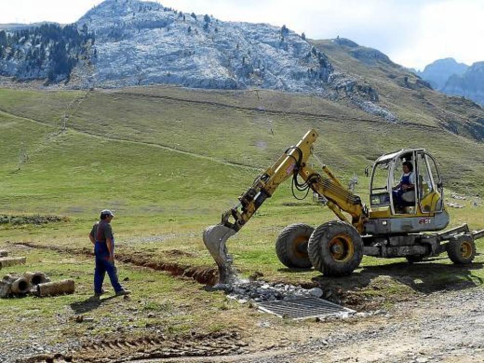 La máquina trabaja para colocar tuberías de conducción de agua para los cañones en Candanchú.
