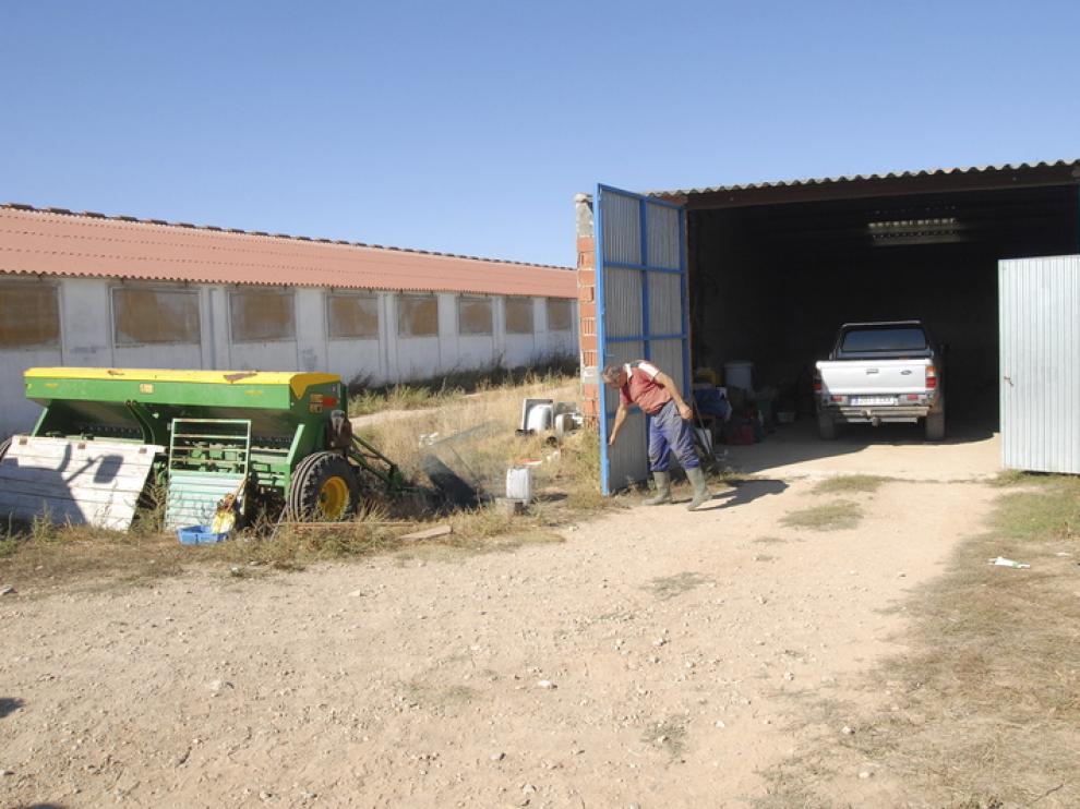 El propietario de un tractor robado abre las puertas de la cochera de donde fue sustraído.