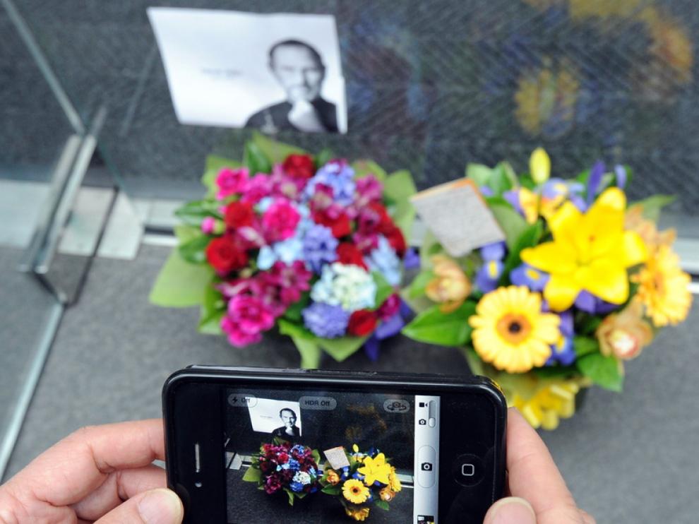 Un ciudadano toma una foto de un altar improvisado con su iPhone4